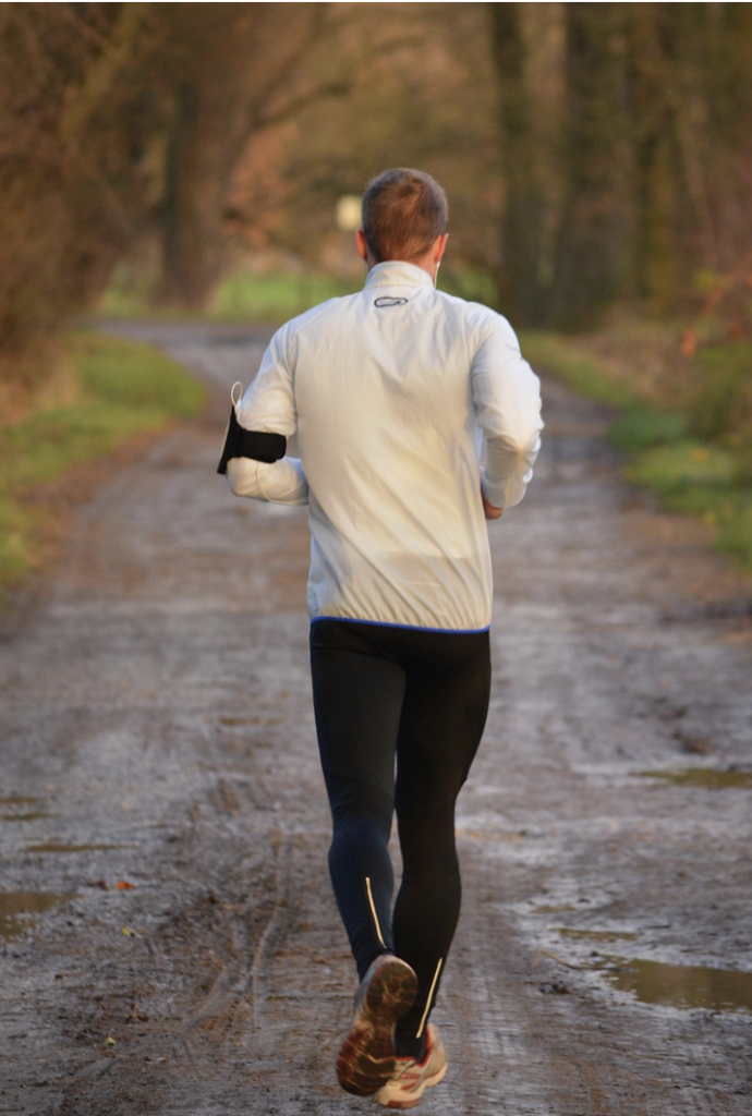 A man running up a mountain trail, illustrating the process of building a high-energy lifestyle after porn.